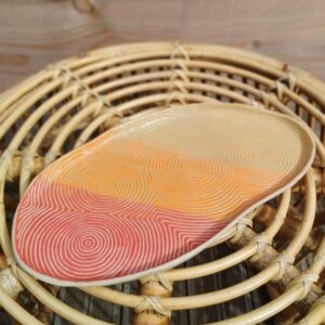 Plat "sillon" rouge orange et jaune, en céramique artisanale, gravé de lignes concentriques selon la technique du sgraffito