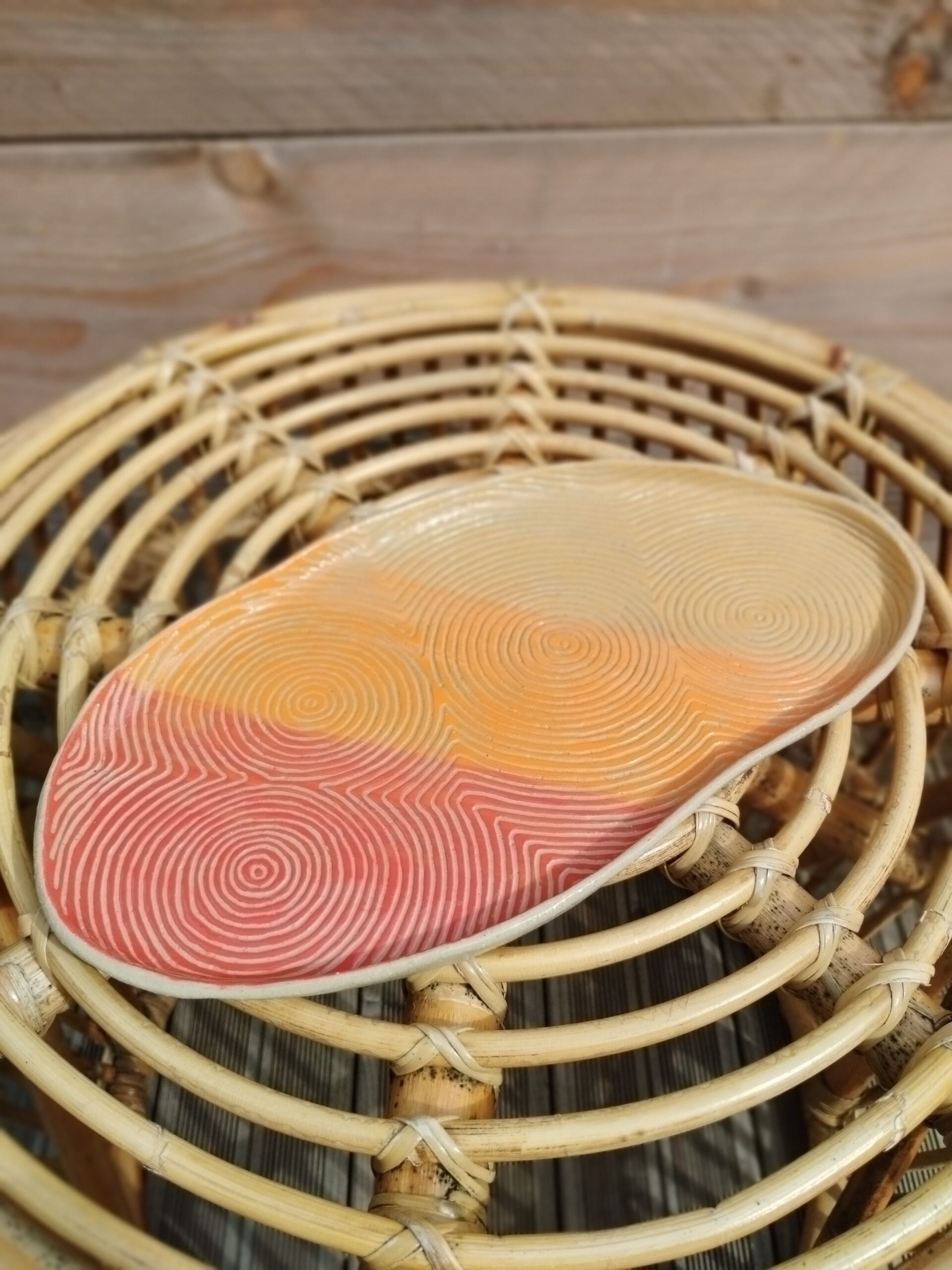 Plat "sillon" rouge orange et jaune, en céramique artisanale, gravé de lignes concentriques selon la technique du sgraffito
