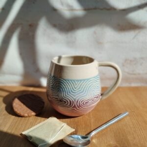Mug "sillon" nuage. Céramique artisanale. Poterie en dégradé de rose à bleu. Motif de lignes gravées évoquant les nuages
