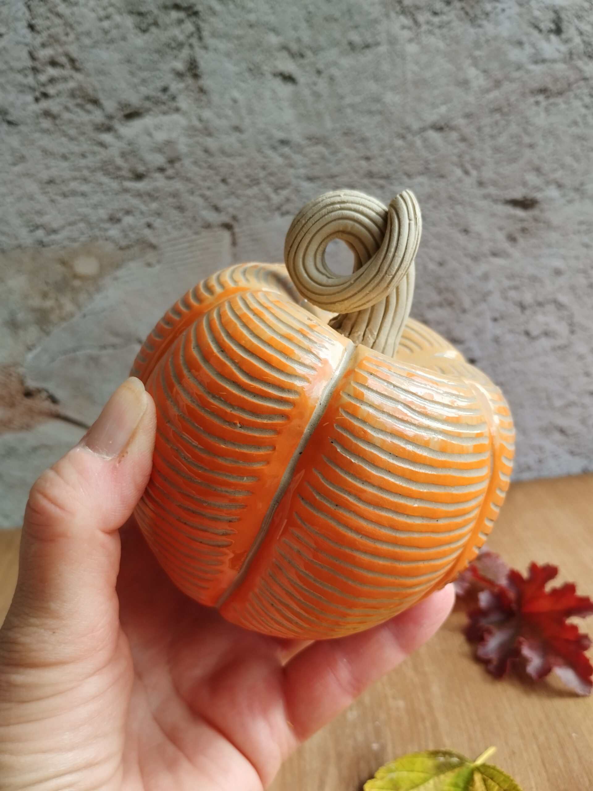 Citrouille en céramique artisanale orange. Motif de lignes gravées horizontales
