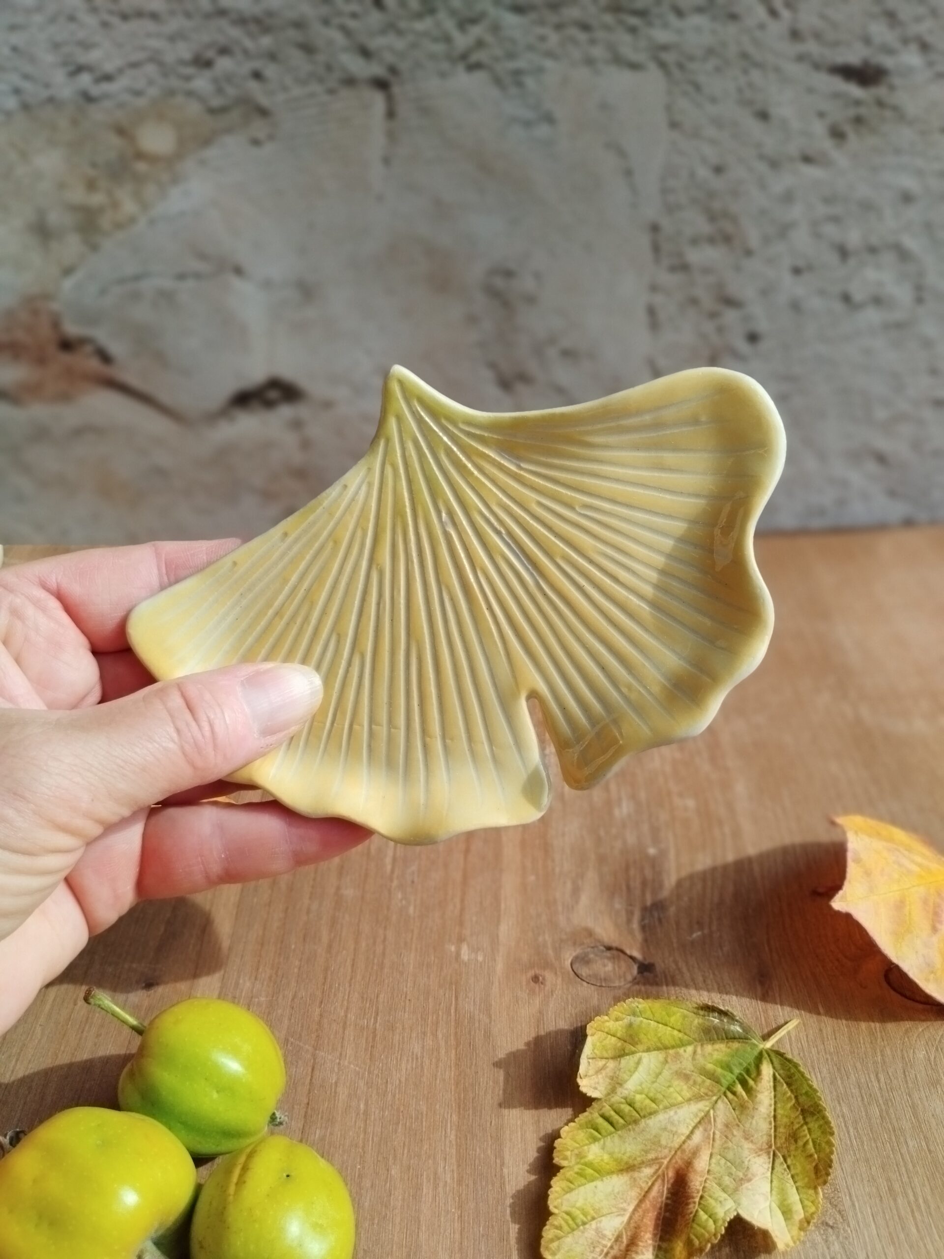Coupelle à bijoux en céramique artisanale. Forme de feuille de ginkgo. Fond en dégradé de couleur jaune doré et vert clair