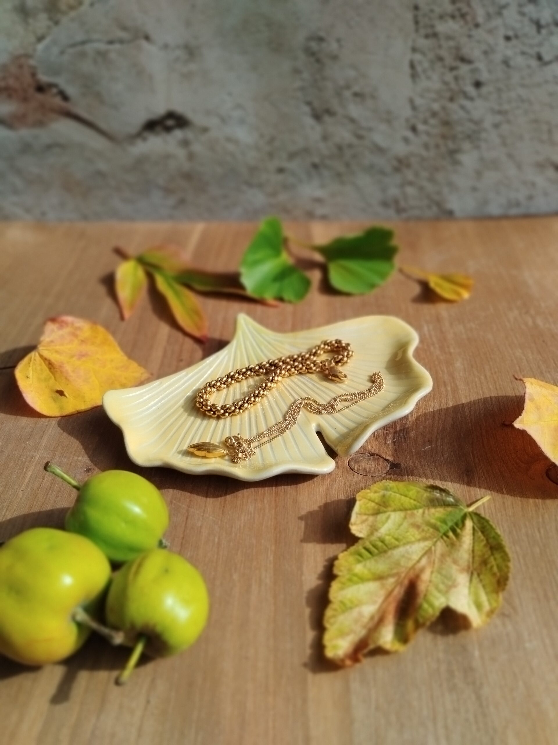 Coupelle à bijoux en céramique artisanale. Forme de feuille de ginkgo. Fond en dégradé de couleur jaune doré et vert clair