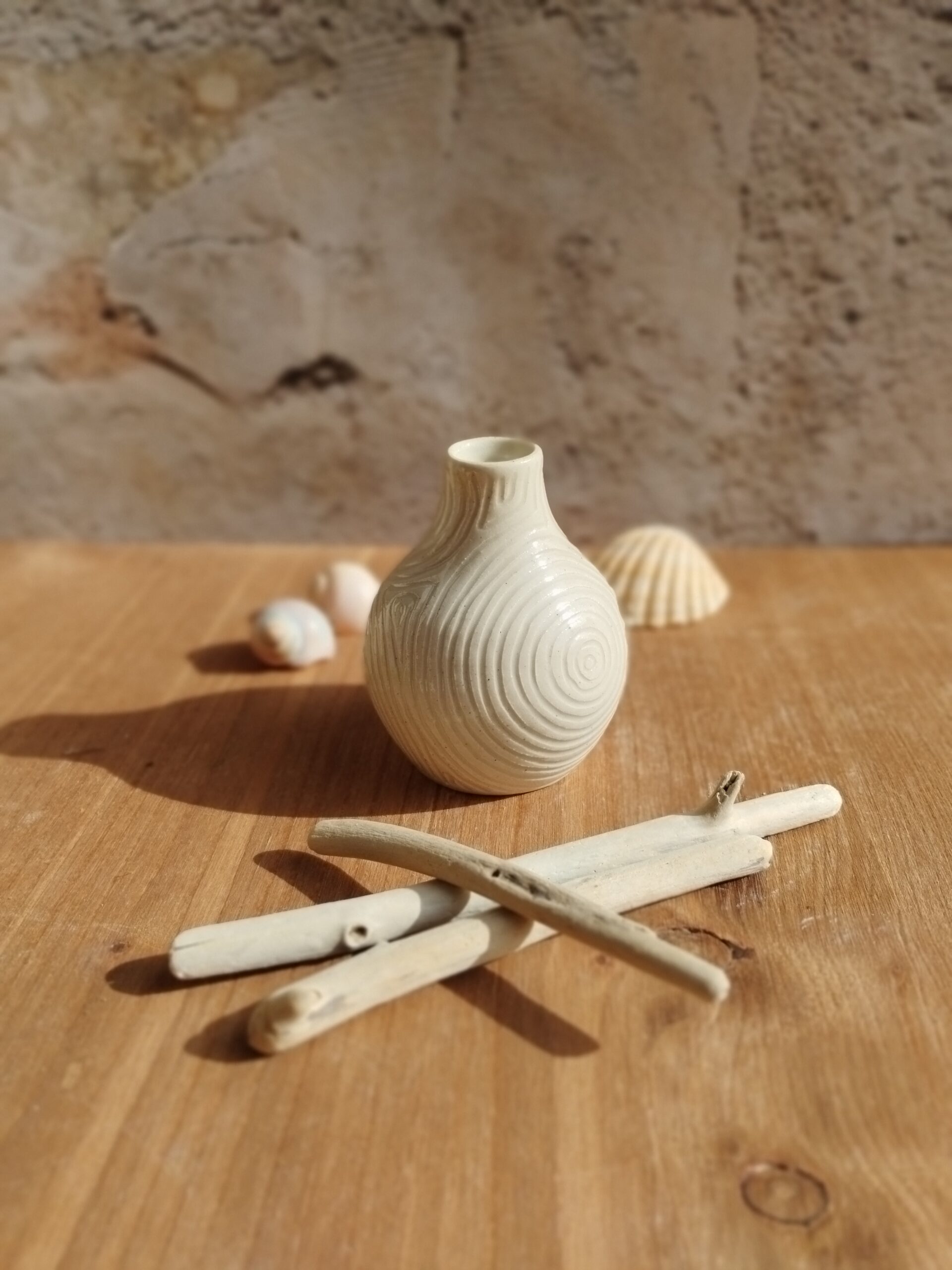 Mini vase en céramique artisanale écru. Motif de lignes gravées rappelant les mouvements de l'eau