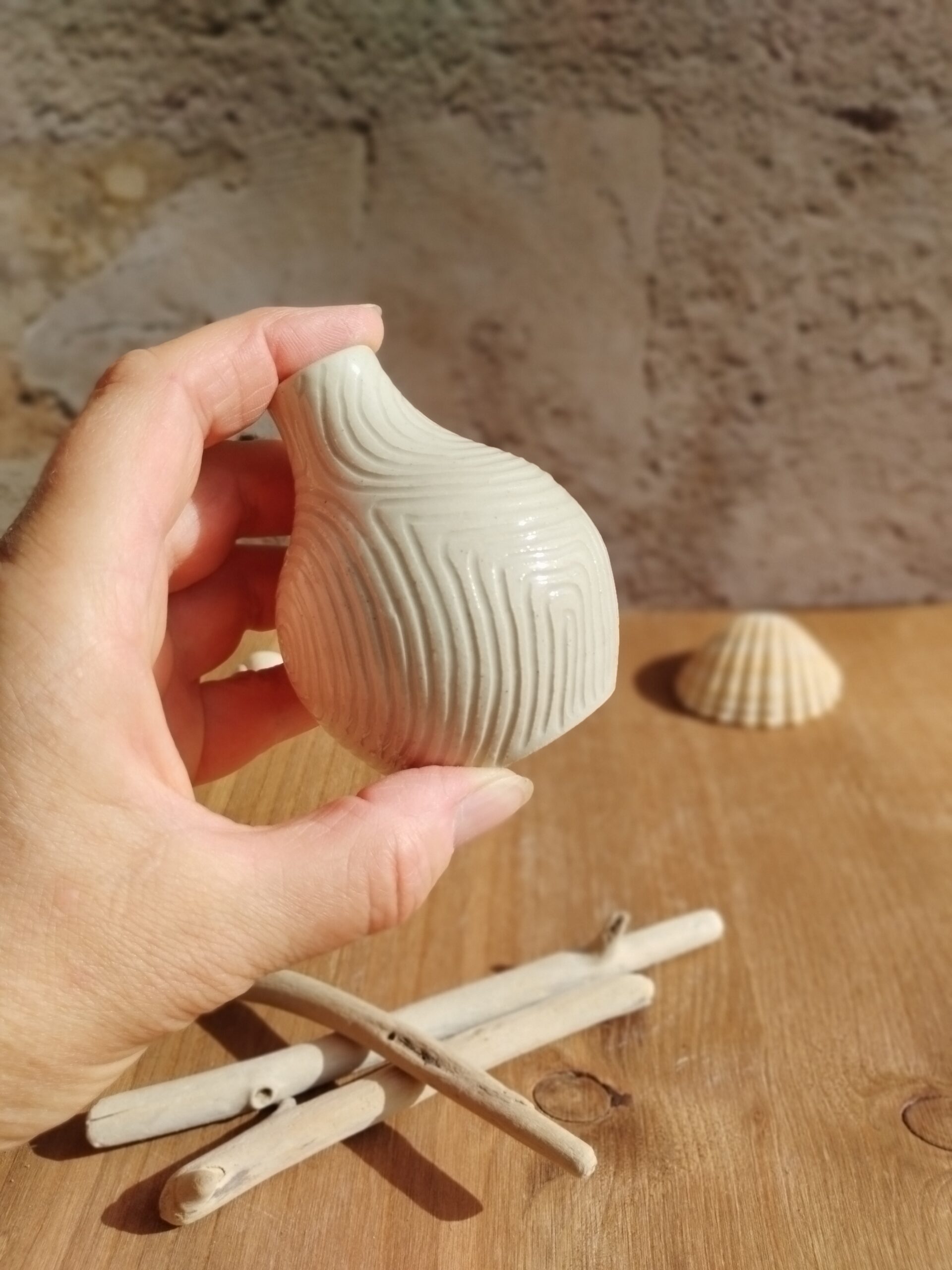 Mini vase en céramique artisanale écru. Motif de lignes gravées rappelant les mouvements de l'eau