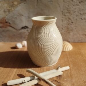 Vase en céramique artisanale écru. Motif de lignes gravées rappelant les mouvements de l'eau