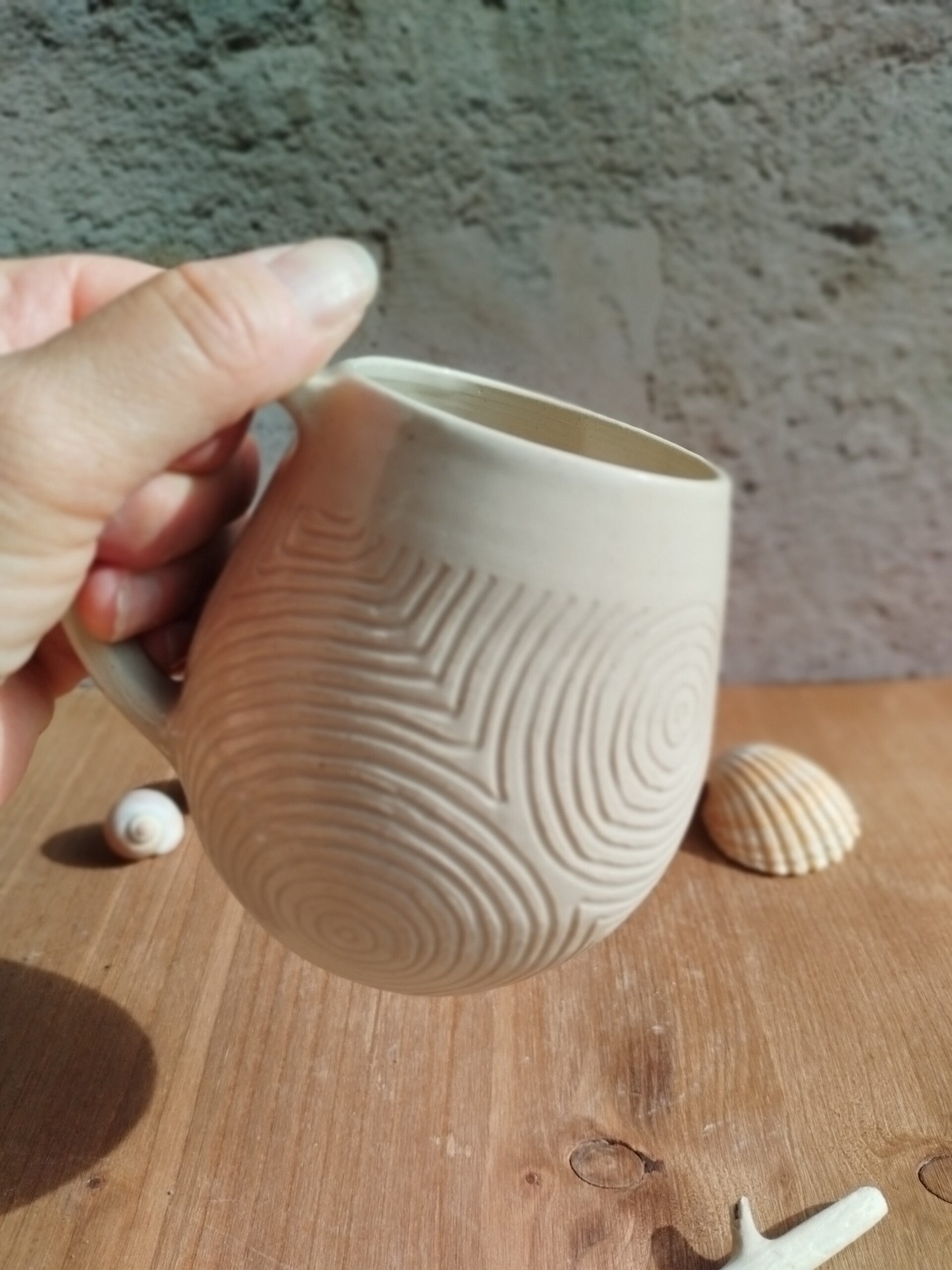 Mug en céramique artisanale écru. Motif de lignes gravées rappelant les
