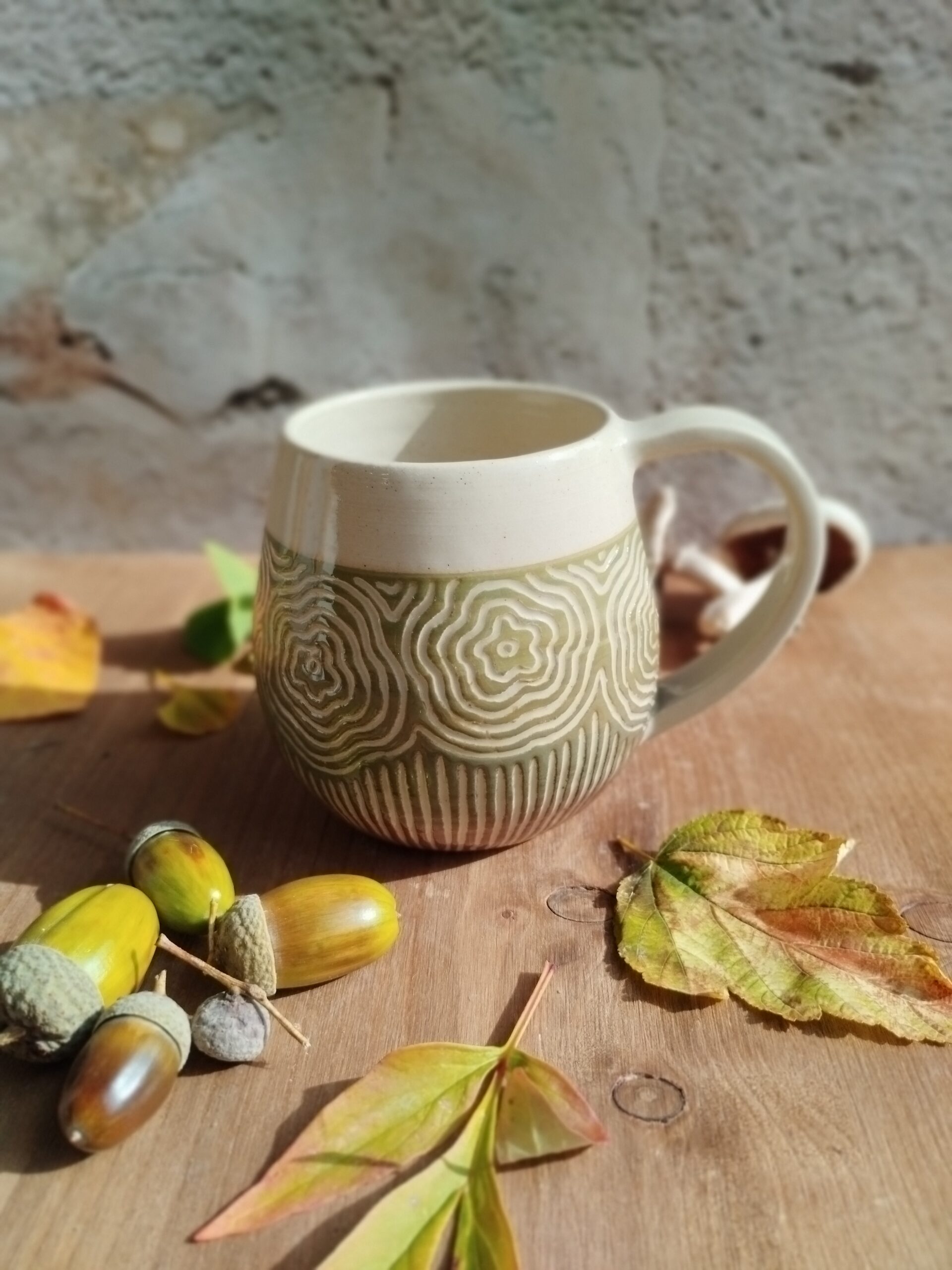 Mug en céramique artisanale. Fond en dégradé de vert à brun. Motifs gravés arbres