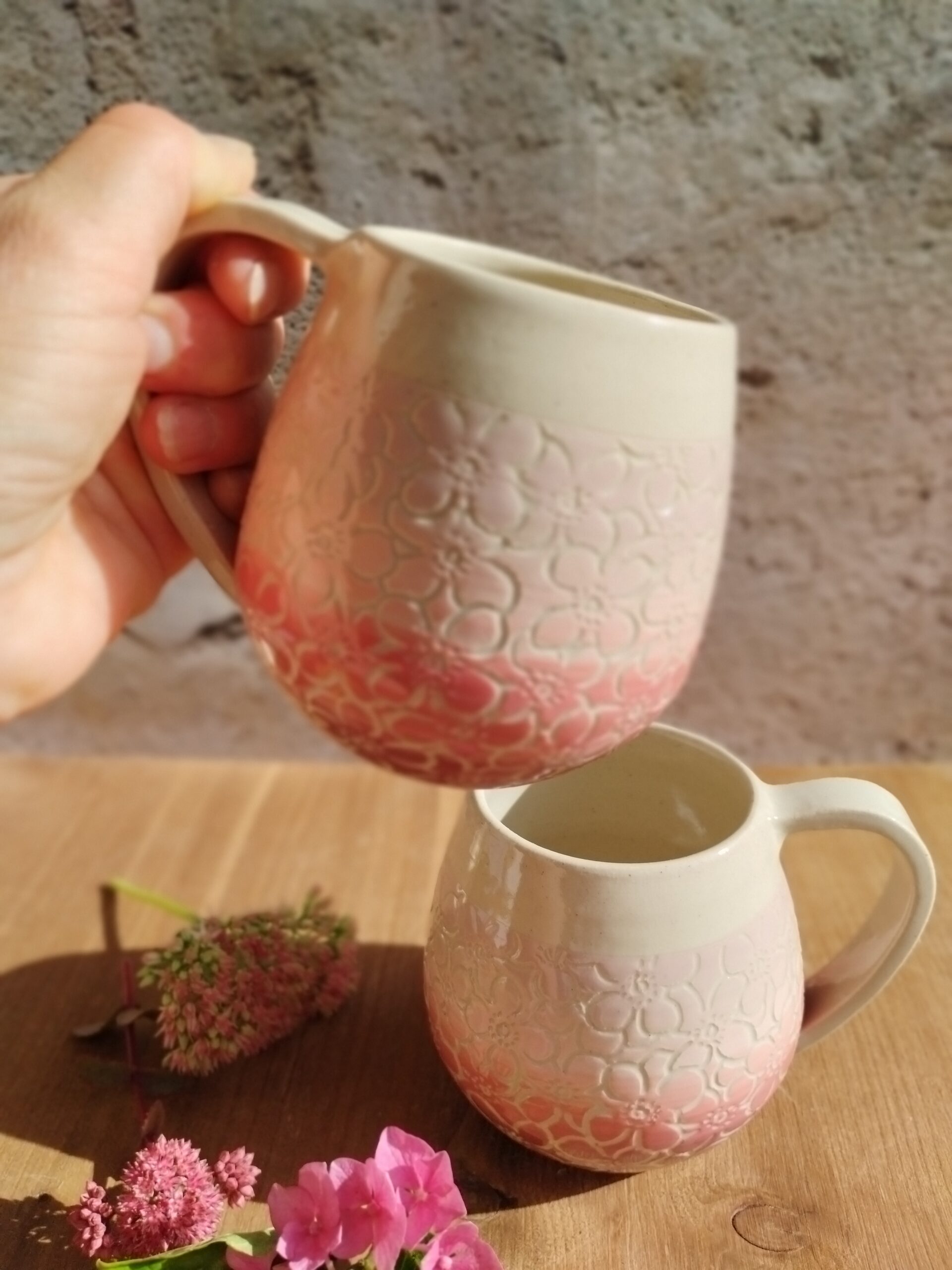 Mug en céramique artisanale. Fond coloré en dégradé de roses, motifs hortensia gravés