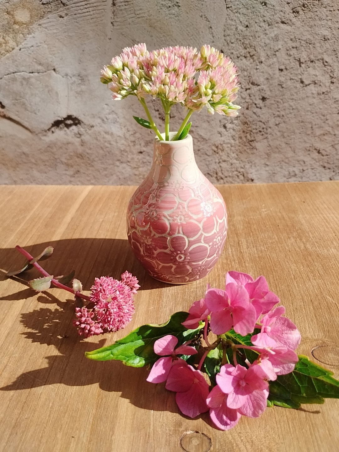 Mini vase en céramique artisanale. Fond en dégradé de roses. Motifs de fleurs d'hortensia gravés