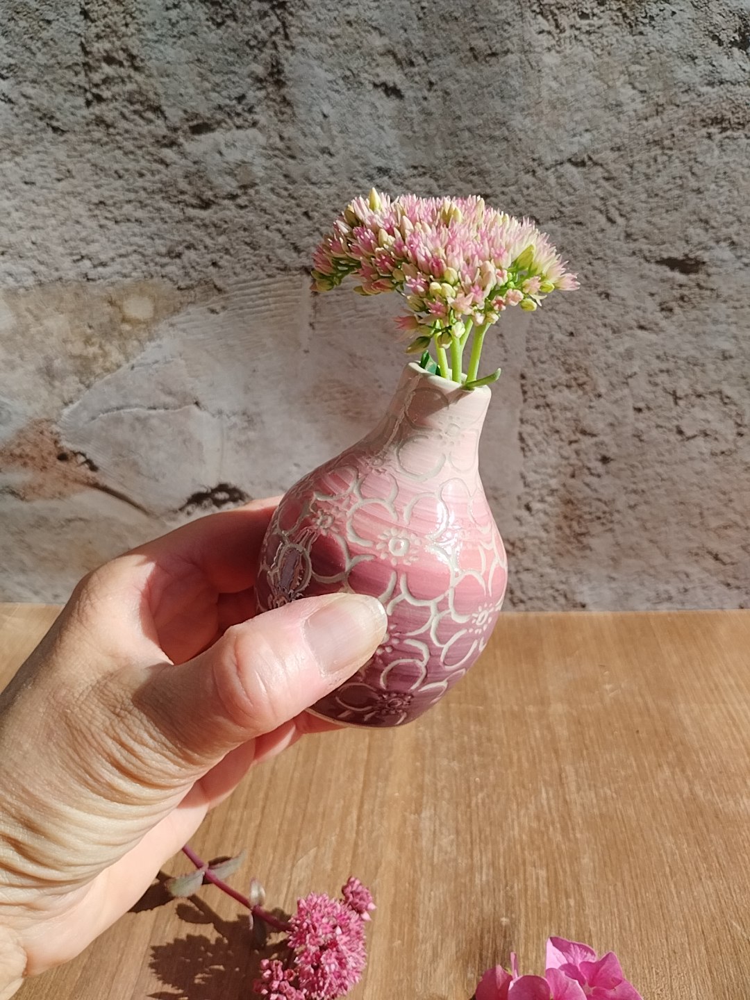 Mini vase en céramique artisanale. Fond en dégradé de roses. Motifs de fleurs d'hortensia gravés