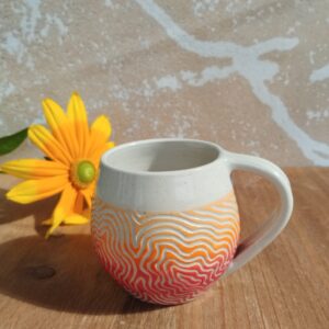 Tasse en céramique artisanale. Fond coloré en dégradé de rouge orange. Motif gravé feuille de chêne