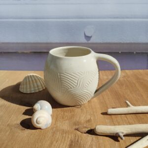 Tasse en céramique artisanale écrue. Motif de lignes gravées aquatique