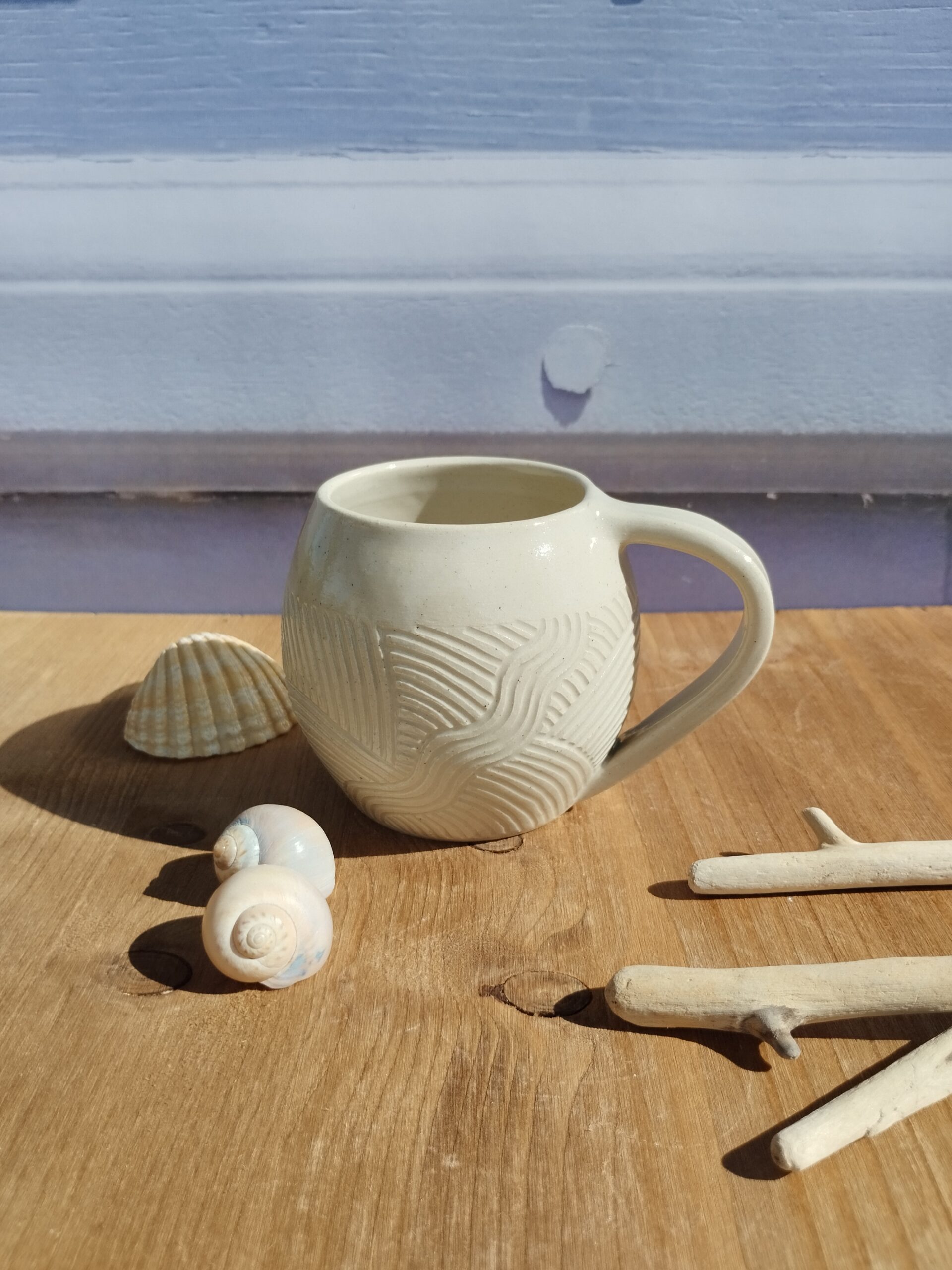 Tasse en céramique artisanale écrue. Motif de lignes gravées aquatique