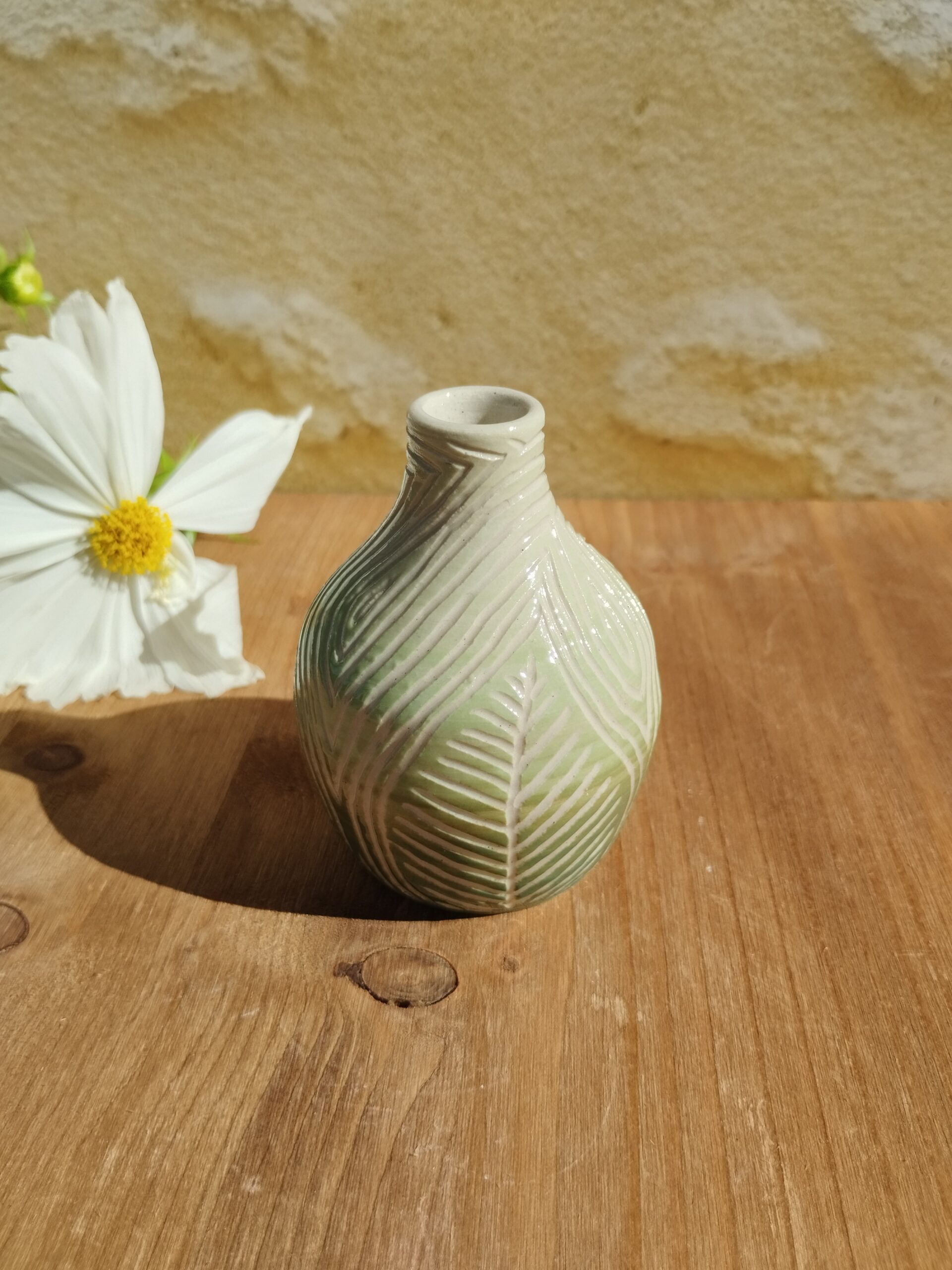Mini vase en céramique artisanale. Fond en dégradé de vert. Motif de feuillage gravé