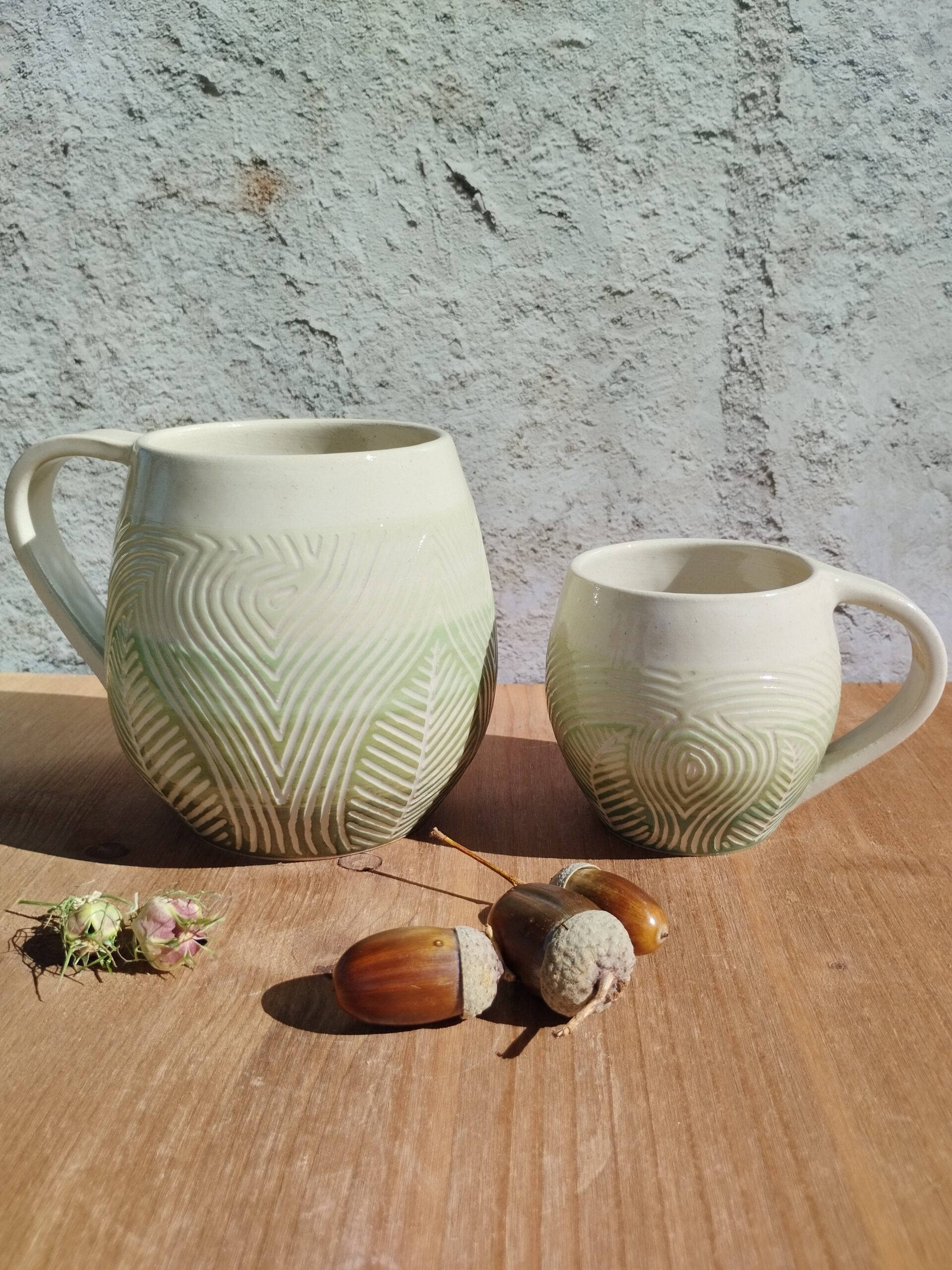 Grand mug et tasse en céramique artisanale. Fond en dégradé de vert. Motif de feuillage gravé