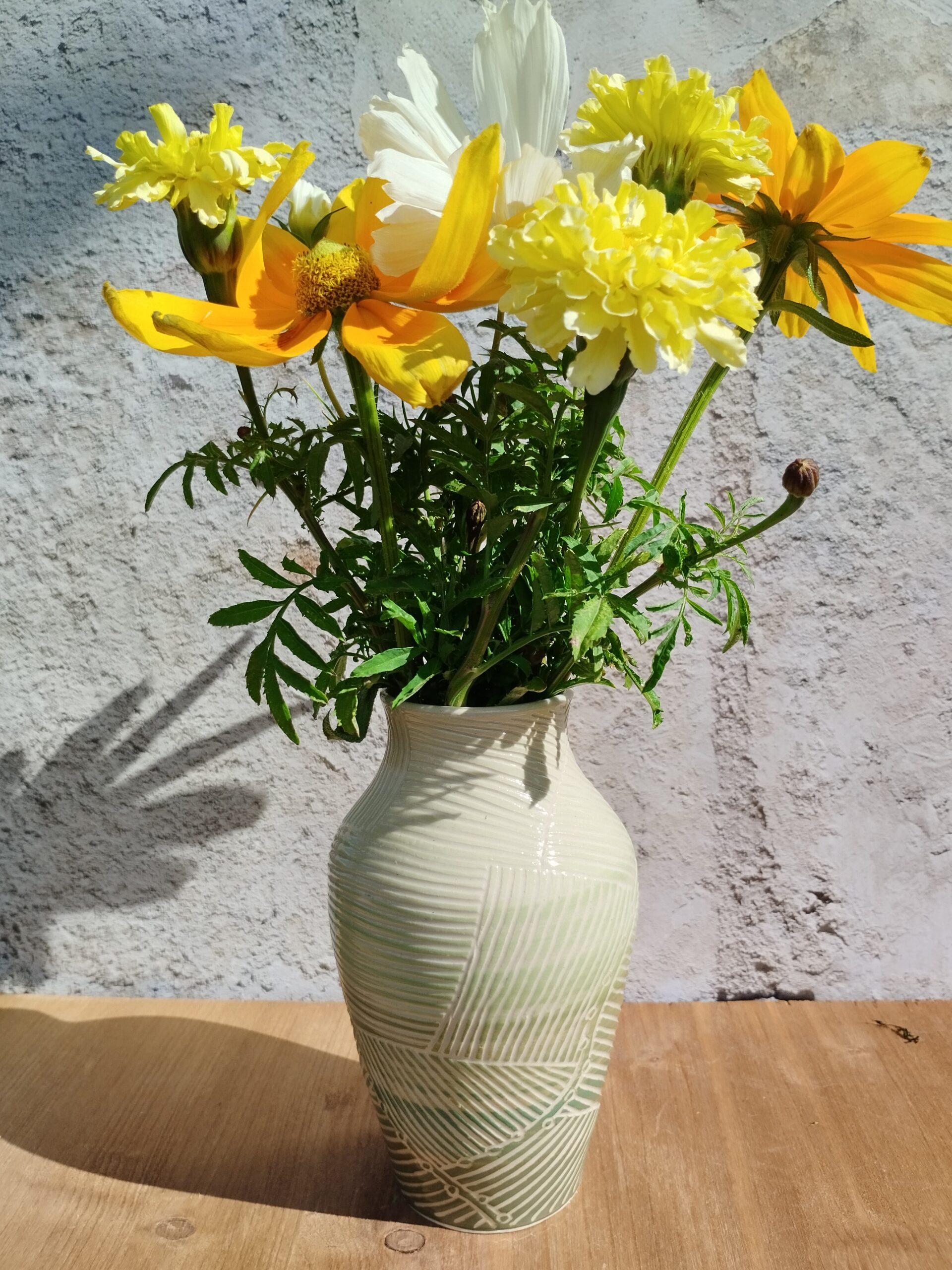 Vase en céramique artisanale. Fond coloré en dégradé de vert. Motif de lignes gravées