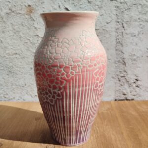 vase en céramique artisanale. Fond en dégradé de rose. Motif de lignes gravées