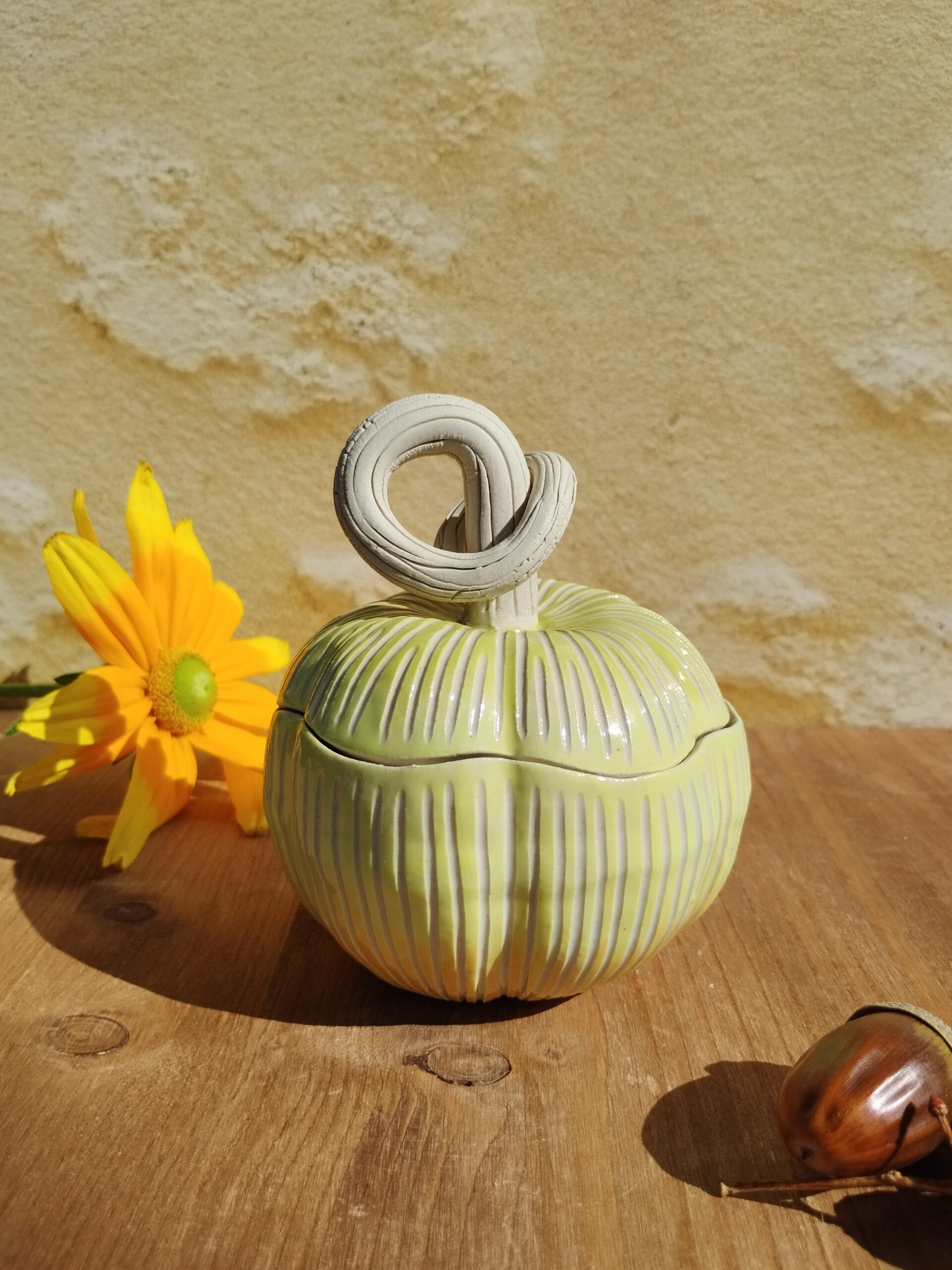 Boite en céramique artisanale en forme de citrouille jaune. Motif de lignes gravées verticales