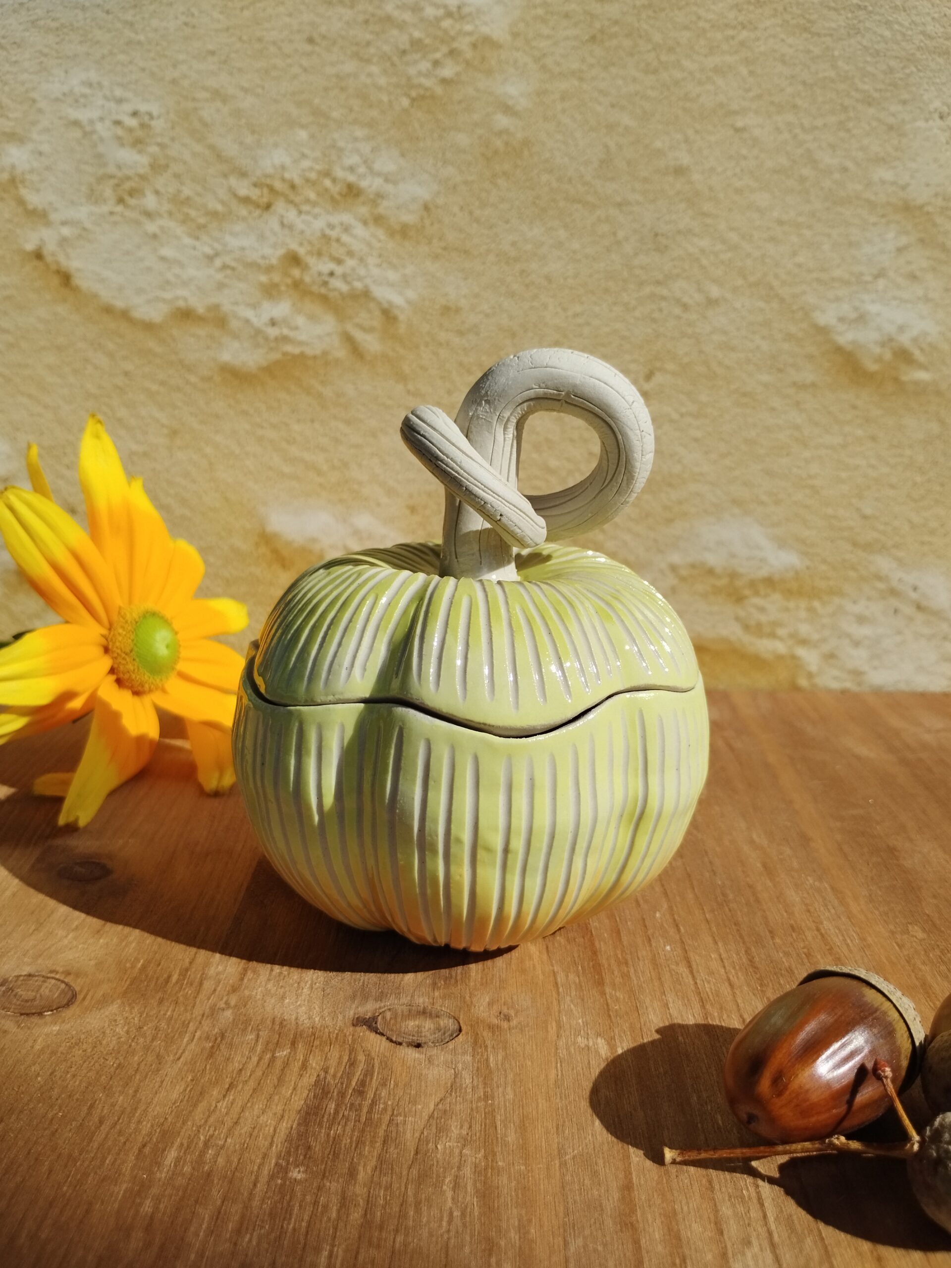 Boite en céramique artisanale en forme de citrouille jaune. Motif de lignes gravées verticales