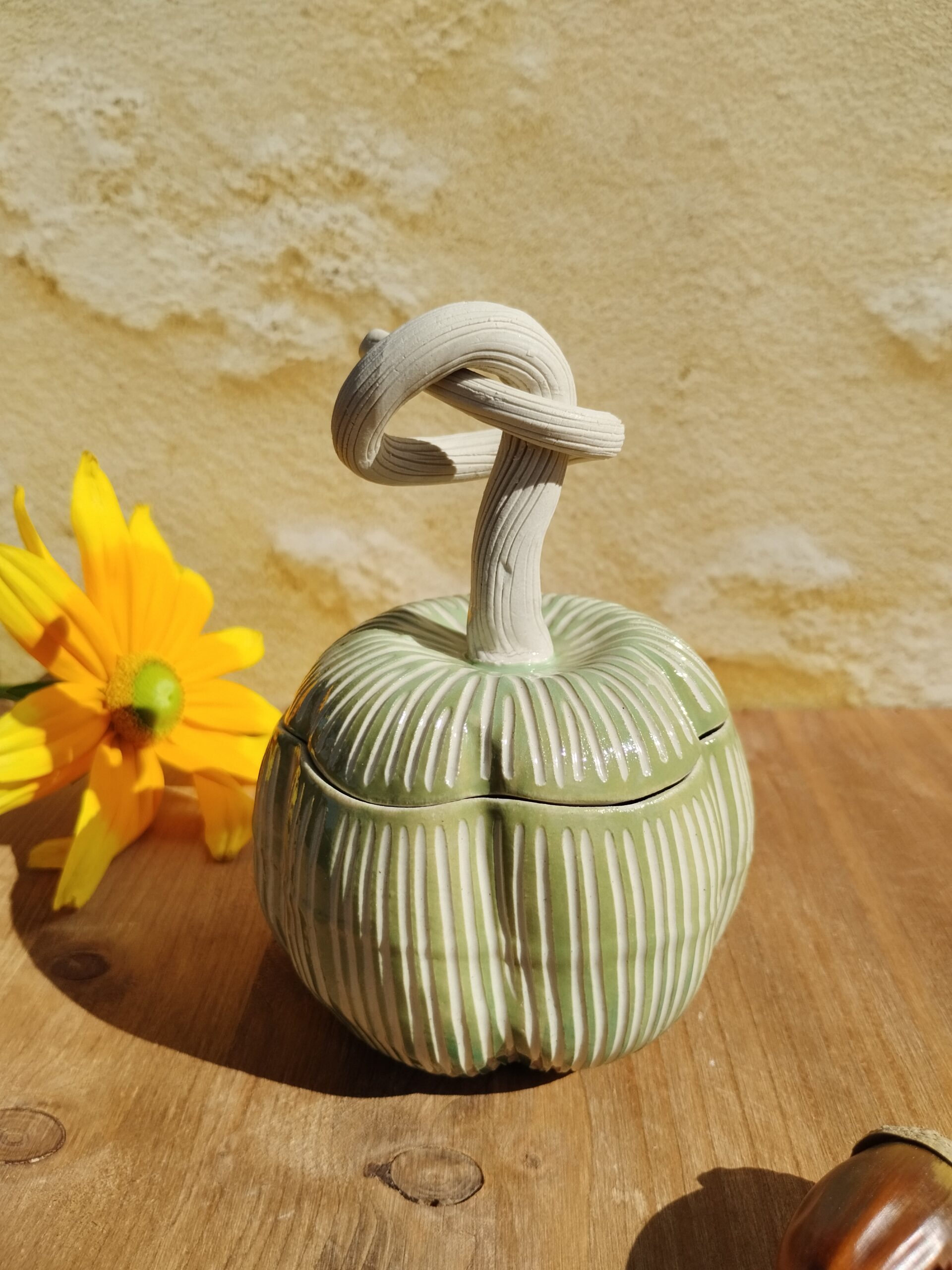 Boite en céramique artisanale en forme de citrouille verte. Motif de lignes gravées verticales