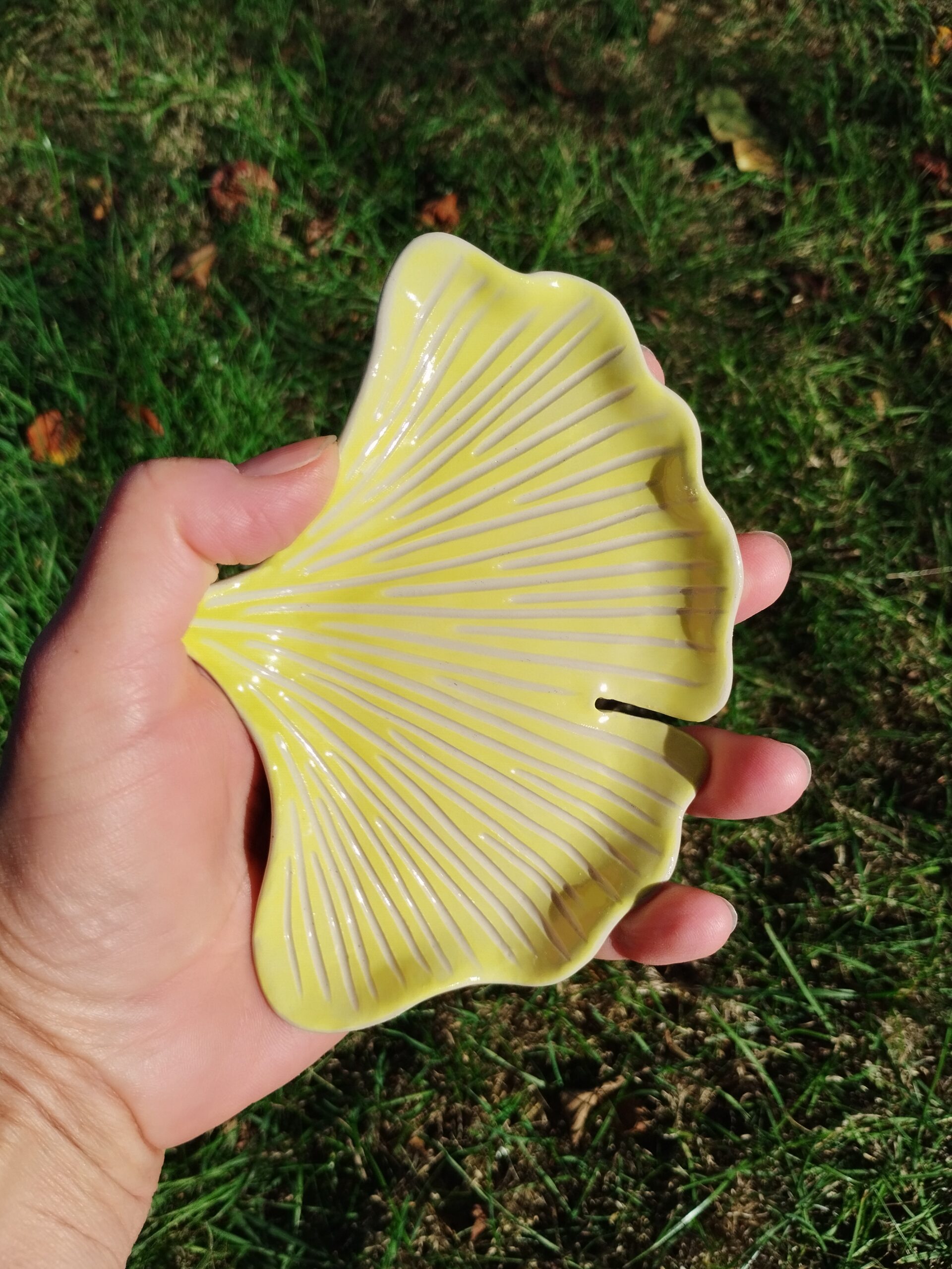 Coupelle à bijoux en céramique artisanale. Fond coloré en dégradé de jaune vif et vert clair. Motif de nervures gravées.