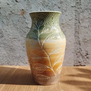 Vase en céramique artisanale. Fond en dégradé de vert à brun. Motif gravé de feuilles d'eucalyptus