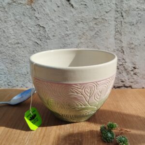 Grand bol en céramique artisanale. Fond en dégradé de rose à vert. Motif gravé feuilles d'eucalyptus
